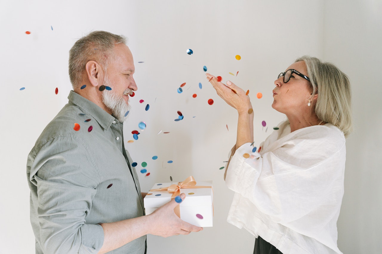 wife-giving-gift-to-husband-blowing-confetti
